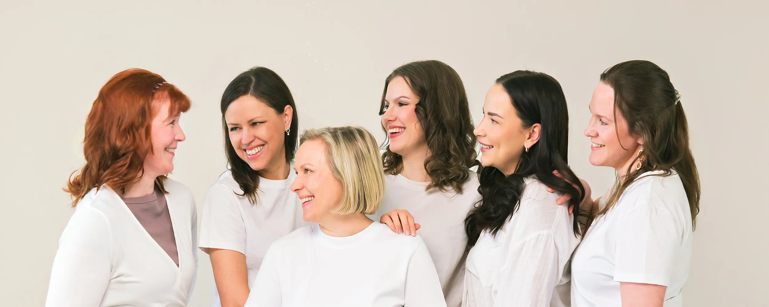 Group of women standing together against a plain background