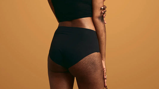 Person with stretchmarks wearing black high-waisted undewear.