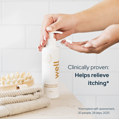 Person applying cream from a Well by Orion Pharma Gentle Cleansing & Moisturizing Cream bottle on a neutral background