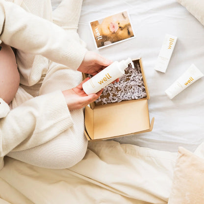 Person holding a 'well' branded product with more products and a magazine in the background.