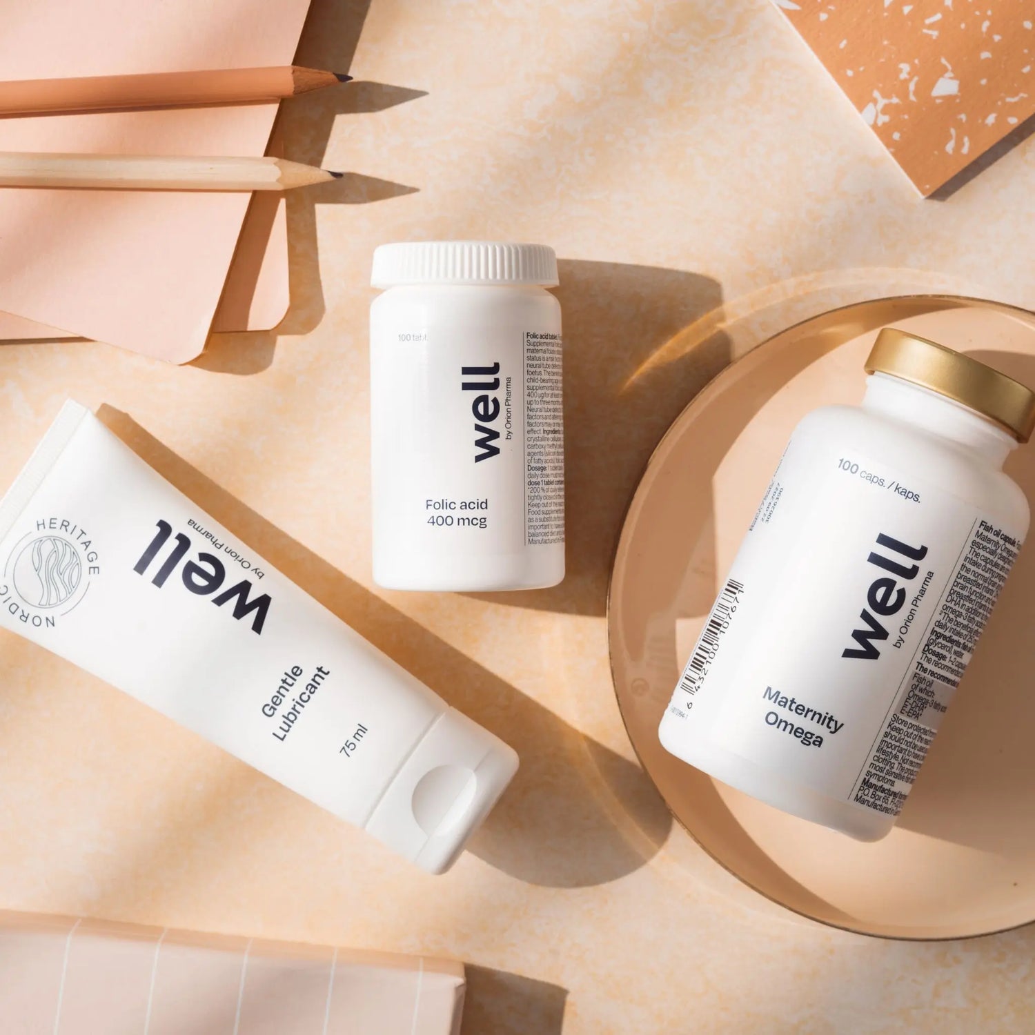 Three 'well' branded supplement bottles on a beige surface