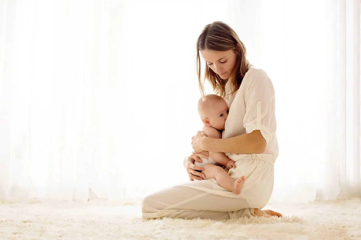 Woman holding a baby in a softly lit room