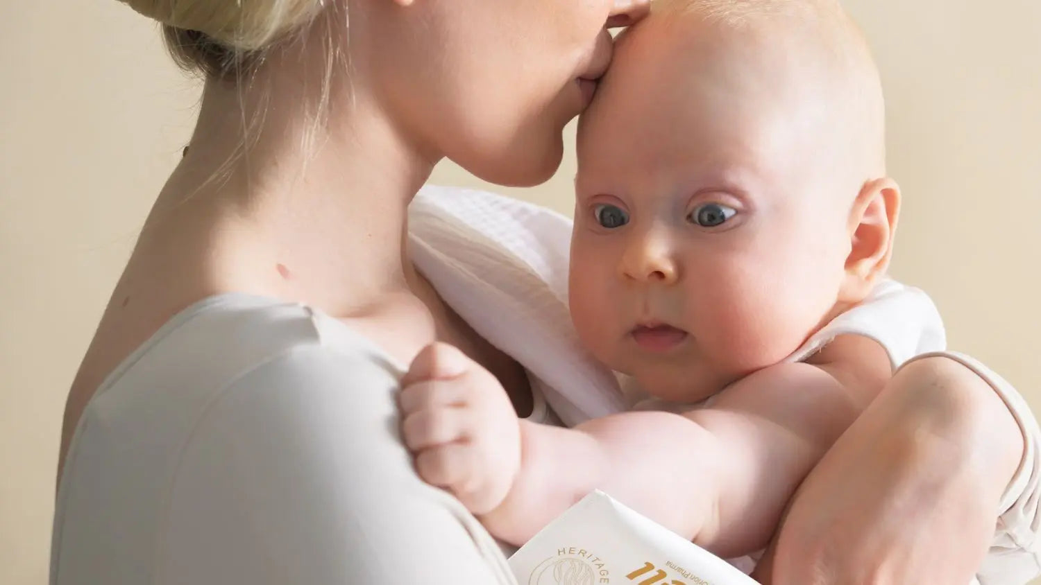 Woman holding a baby close to her chest with a soft background