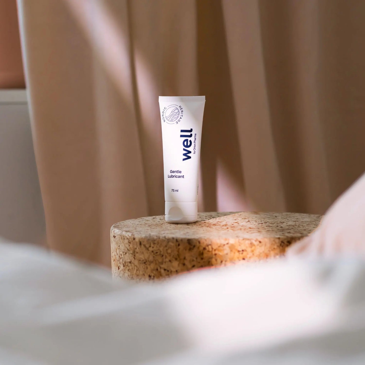 Tube of 'well' lubricant on a cork surface with a blurred background