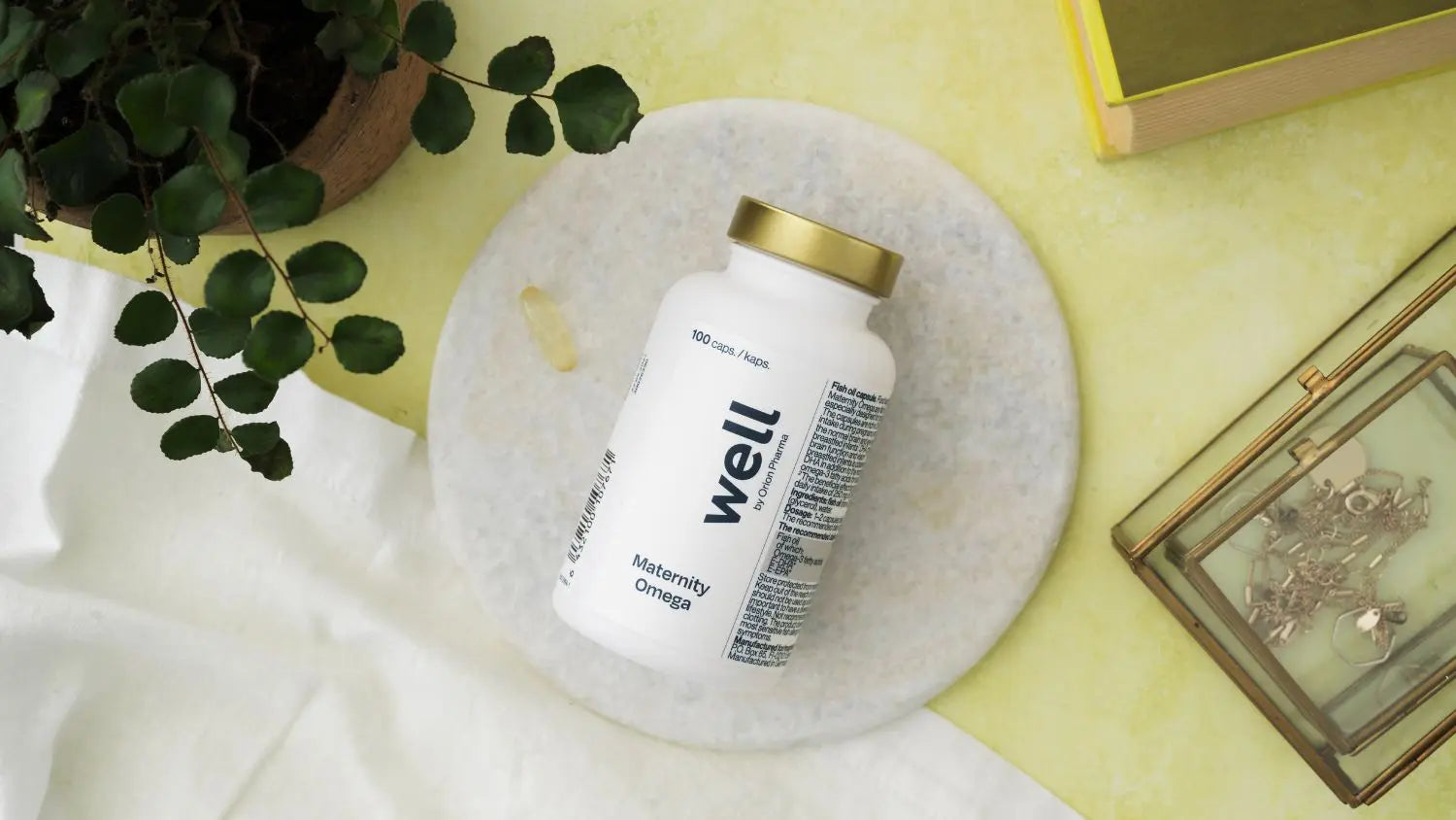 Bottle labeled 'well' on a marble surface with a yellow background