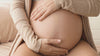 Pregnancy belly being stroked, mama bundle products in use.